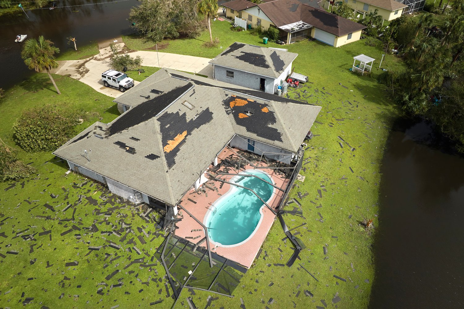http://Hurricane%20Ian%20destroyed%20house%20roof%20in%20Florida%20residential%20area.%20Natural%20disaster%20and%20its%20consequences.