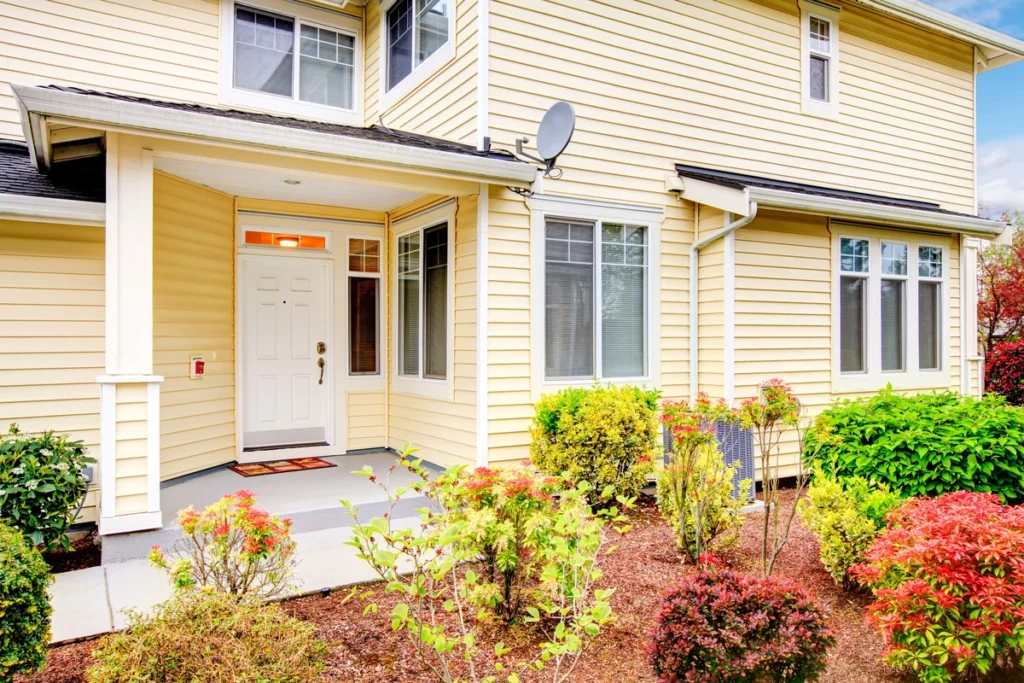 classic ivory vinyl siding on house with garden