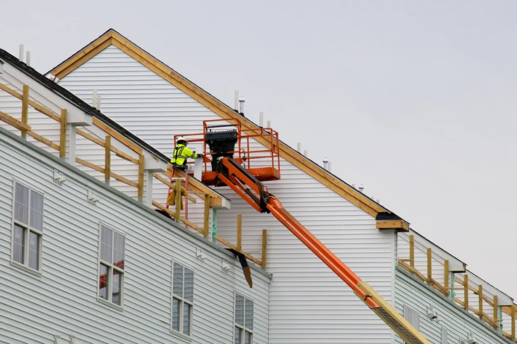 construction team installing siding panels on large building
