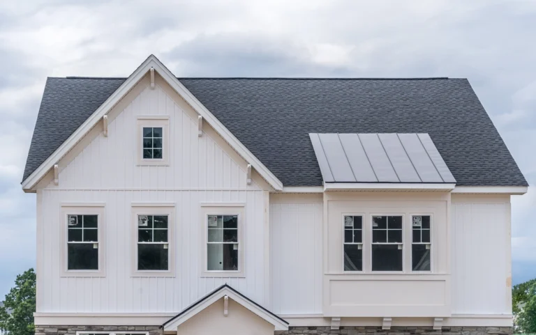 family house with white vertical siding and solar panels on the roof