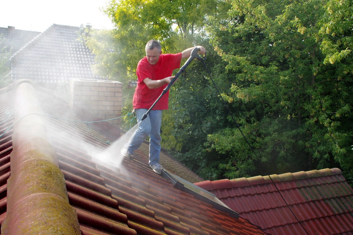 man washing his house roof
