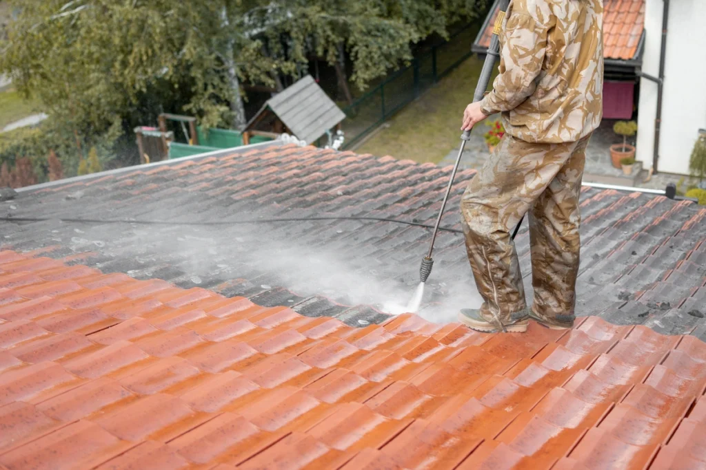 man washing the roof of the house